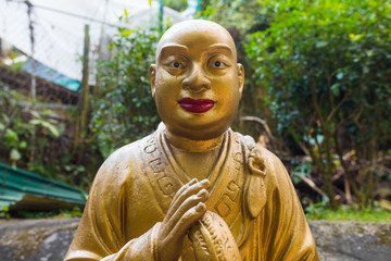 Beautiful unique buddha statue close shot, looking at the camera. Golden religious sculpture representing a buddhist/monk. Ten Thousand Buddhas Monastery, Sha Tin, Hong Kong. Peaceful prayer