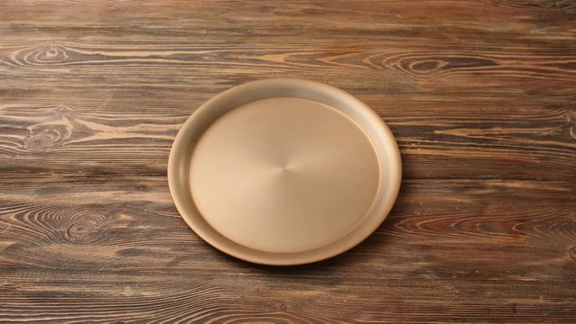 Male waiter opening empty tray on wooden background