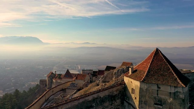 Aerial view of View of Rasnov Fortress and Rasnov city at sunset in Brașov, Transylvania, Romania