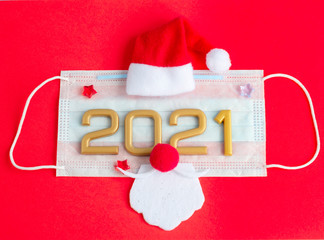 New year numbers 2021, Santa Claus hat and beard on face mask on a red background, creative minimal concept of Christmas