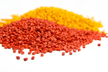 Red and orange plastic polymer granules isolated on white 