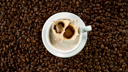 Falling sugar canes into cup of hot coffee