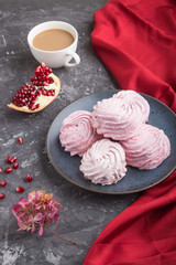 Pink pomegranate homemade zephyr or marshmallow with cup of coffee on a black concrete background....
