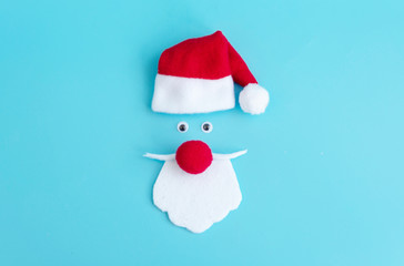 Santa Claus hat and beard on a blue background, creative minimal concept of Christmas and New Year