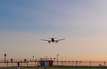 Fototapeta na wymiar Airplane flies against a background of blue sky