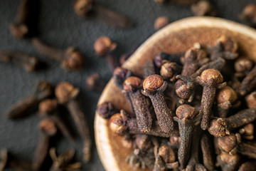 Top view spice clove in a wooden spoon.