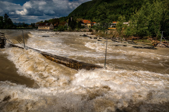 River floods in fall season after heavy rain. High rise river water in Tacen Whitewater Course, Slovenia. Brown and muddy water. High shutter speed photo.