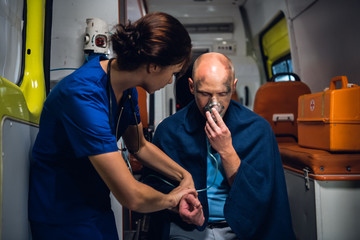 A young paramedic talking to an injured man, trying to calm him down