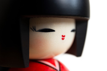 Close up of a kokeshi doll. Macrophotography taken on studio and representing a face of a Japanese traditional doll