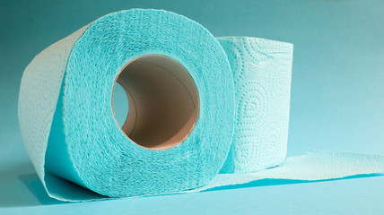 Blue roll of modern toilet paper on a blue background. A paper product on a cardboard sleeve, used for sanitary purposes from cellulose with cutouts for easy tearing. Embossed drawing