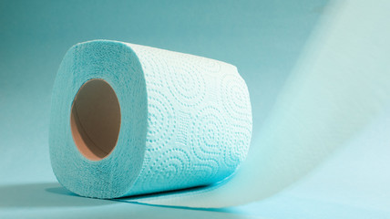 Blue roll of modern toilet paper on a blue background. A paper product on a cardboard sleeve, used for sanitary purposes from cellulose with cutouts for easy tearing. Embossed drawing
