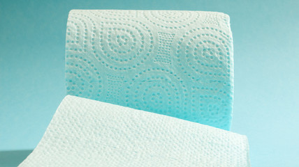 Blue roll of modern toilet paper on a blue background. A paper product on a cardboard sleeve, used for sanitary purposes from cellulose with cutouts for easy tearing. Embossed drawing