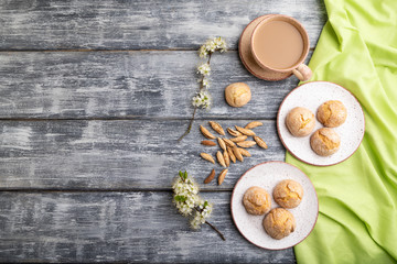 Almond cookies and a cup of coffee on a gray wooden background. Top view, copy space.