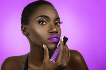 Closeup of a gorgeous young black female’s face with beautiful makeup and luscious lips posing by...