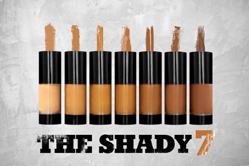 A product group shot of liquid makeup foundations lined up next to each other with respective color stripes - called The Shady 7.