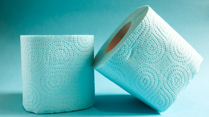 Blue roll of modern toilet paper on a blue background. A paper product on a cardboard sleeve, used for sanitary purposes from cellulose with cutouts for easy tearing. Embossed drawing