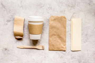 food delivery with paper bags and plastic cup on stone table background top view mockup