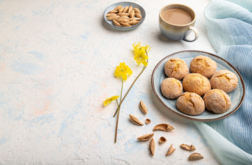 Almond cookies and a cup of coffee on a white concrete background Side view, copy space.