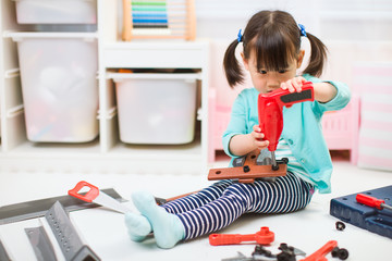 toddler girl pretend using DIY tool at home against white backgrround