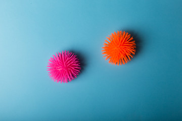 Coronaviruses or the other infectious microbes of orange and pink color sit near each to other isolated on the blue. Concept of protection from the viruses