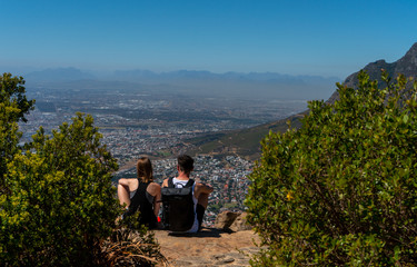 Couple enjoying a beautiful view of Cape Town from the top of Lion's Head mountain. Couple lifestyle concept. 