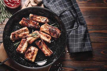 Delicious grilled ribs served on wooden table, flat lay. Food photography