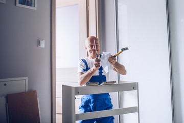 Nervous carpenter assembling furniture and tearing instruction