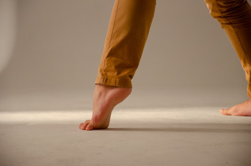 close up on male dancer feet doing some movement with white background