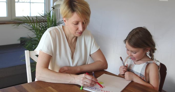 Mother and daughter painting at home