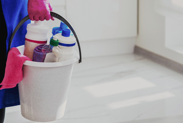 Bucket of detergents. Against the background of a white beautiful modern kitchen.