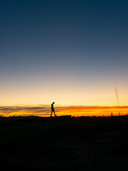 Man walking at sunset silhouette 