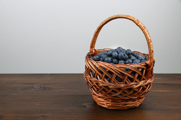 Fototapeta na wymiar blueberry berries in wicker basket on wooden table with copy space