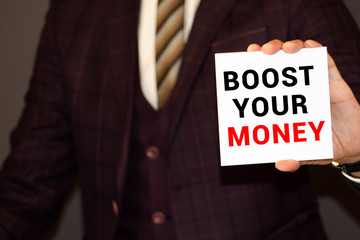 Boost Your Income. Man holding a card with a message text written on it