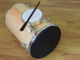 Fototapeta na wymiar Two Brazilian percussion musical instruments: tamborim with drumstick and “tantan” (or “rebolo”) on a wooden surface. They are widely used in samba and pagode ensembles, popular Brazilian rhythms.