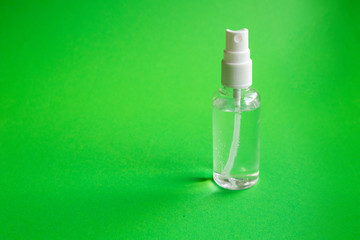 Hand picked alcohol antiseptic on green background. Hygiene and coronavirus prevention concept.