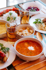 Red Ukrainian borsch with sour cream and other dishes in canteen