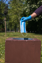 disposing of protective mask in public park bin