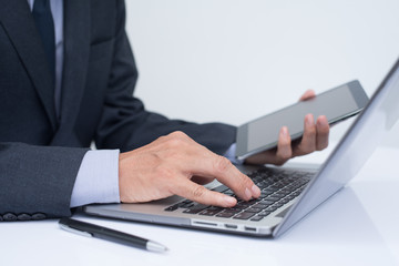 Businessman working on laptop computer and  digital tablet