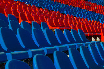 Fototapeta premium The blue and red plastic seats of the football stadium are unlikely
