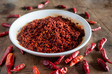 Dried chilies and chili sauce are on the wooden table