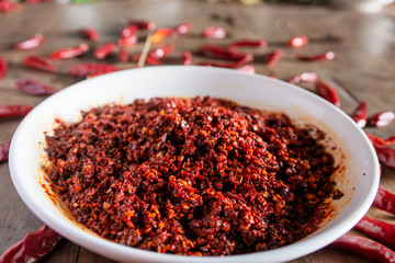 Dried chilies and chili sauce are on the wooden table