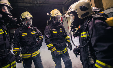 Group of firefighters in the fire department checking their gas mask equipment
