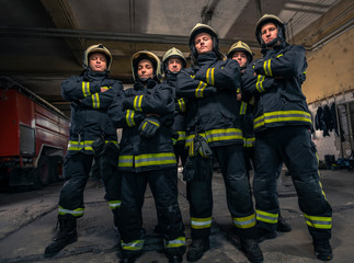 Group of firefighters standing confident with arms crossed. Firemen ready for emergency service.