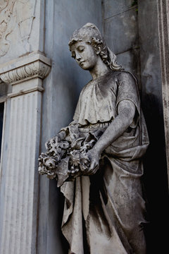 Woman with flowers in a vault in the Recoleta cemetery in Buenos Aires