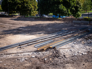 Construction of a metal gate in a car parking. Metal profile channel and pipes on the ground. Parts of the metal structures