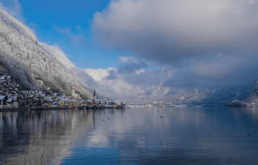 Obraz premium Image of cold and snowy winter in Austria. Beautiful mountain and nature at Hallstatt near Obertraun city opposite the Hallstatter See lake at foggy weather. January 2020