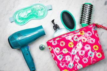 Colorful flat lay of women's styling products in a cosmetic bag