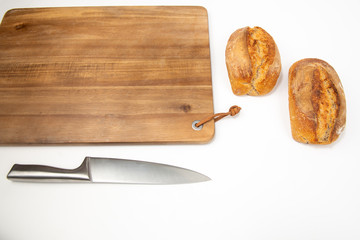 Flat lay packshot chleb z deską, nożem i maselniczką bochenek domowego pieczywa na dużej desce...