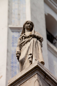 Sculpture of a young woman with a cross in her hands at the Recoleta Cemetery in Buenos Aires