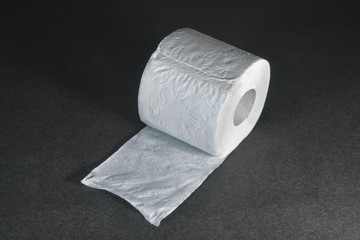 A roll of white toilet paper on a dark background.